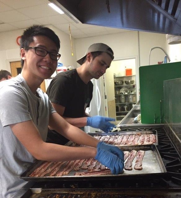 Ryan and Liam making bacon for the YWCA breakfast. Ryan is at least looking at the camera